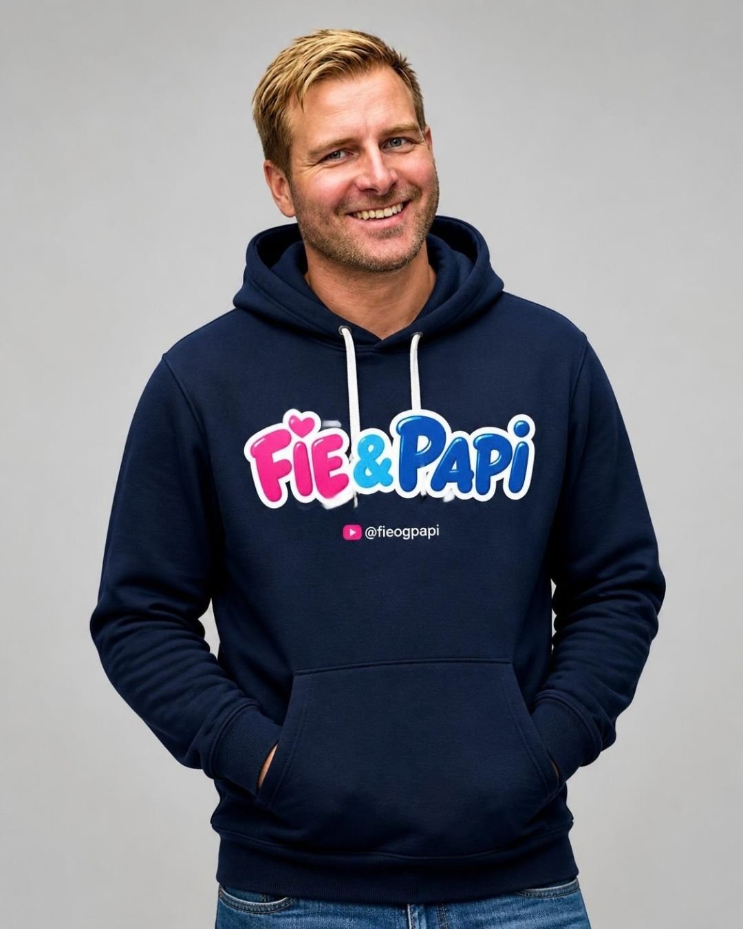 En mann i marineblå hettegenser med Fie & Papi-skriften og @fieogpapi på brystet
